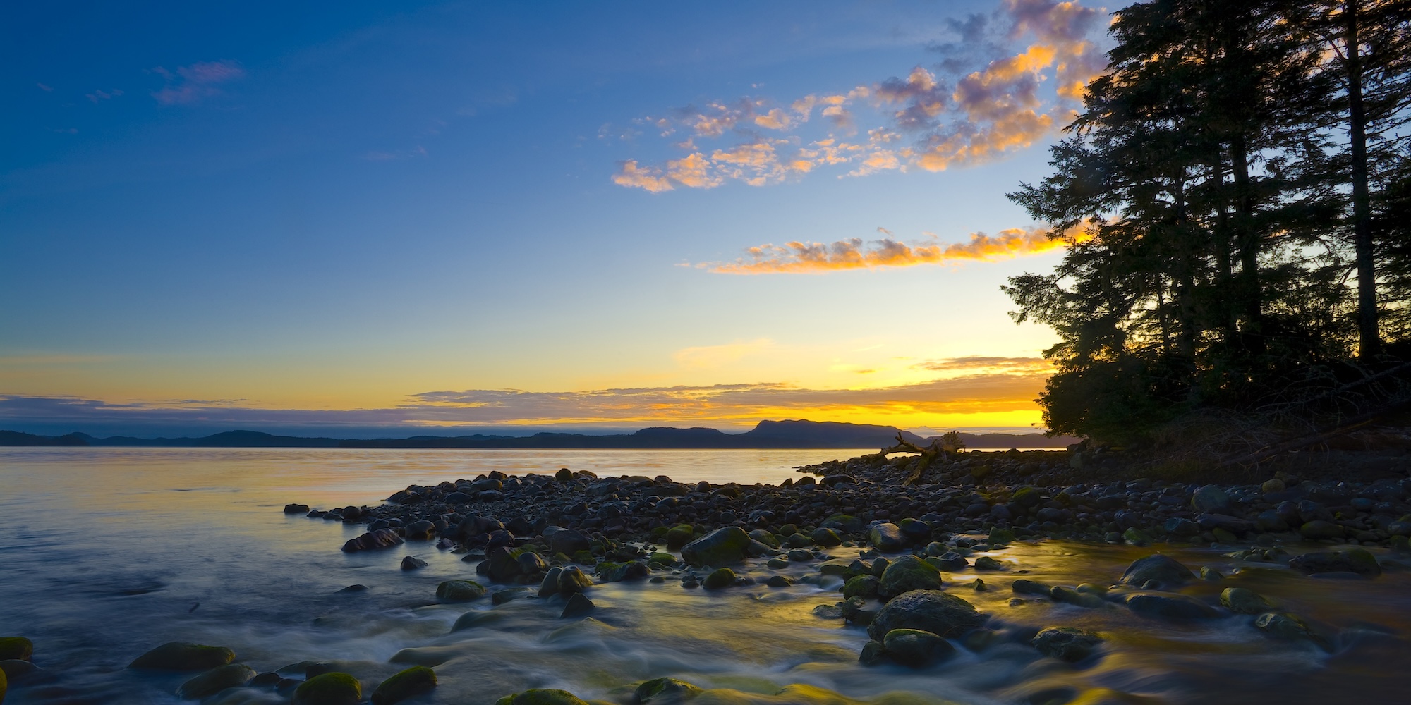 The sun setting over the ocean off on the North Coast trail in British Columbia.