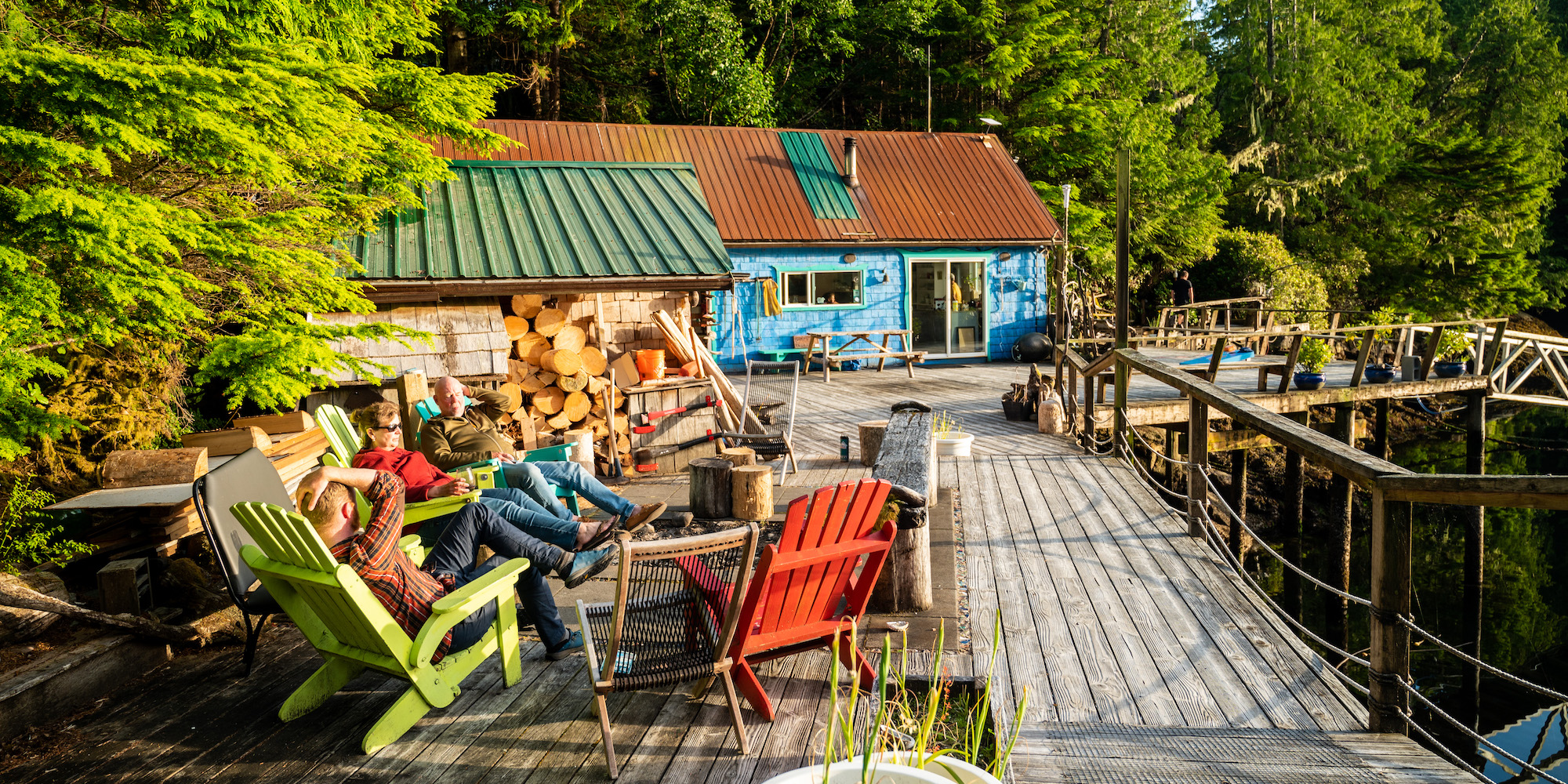 People sitting in adirondack chairs on a deck at God's Pocket resort in BC