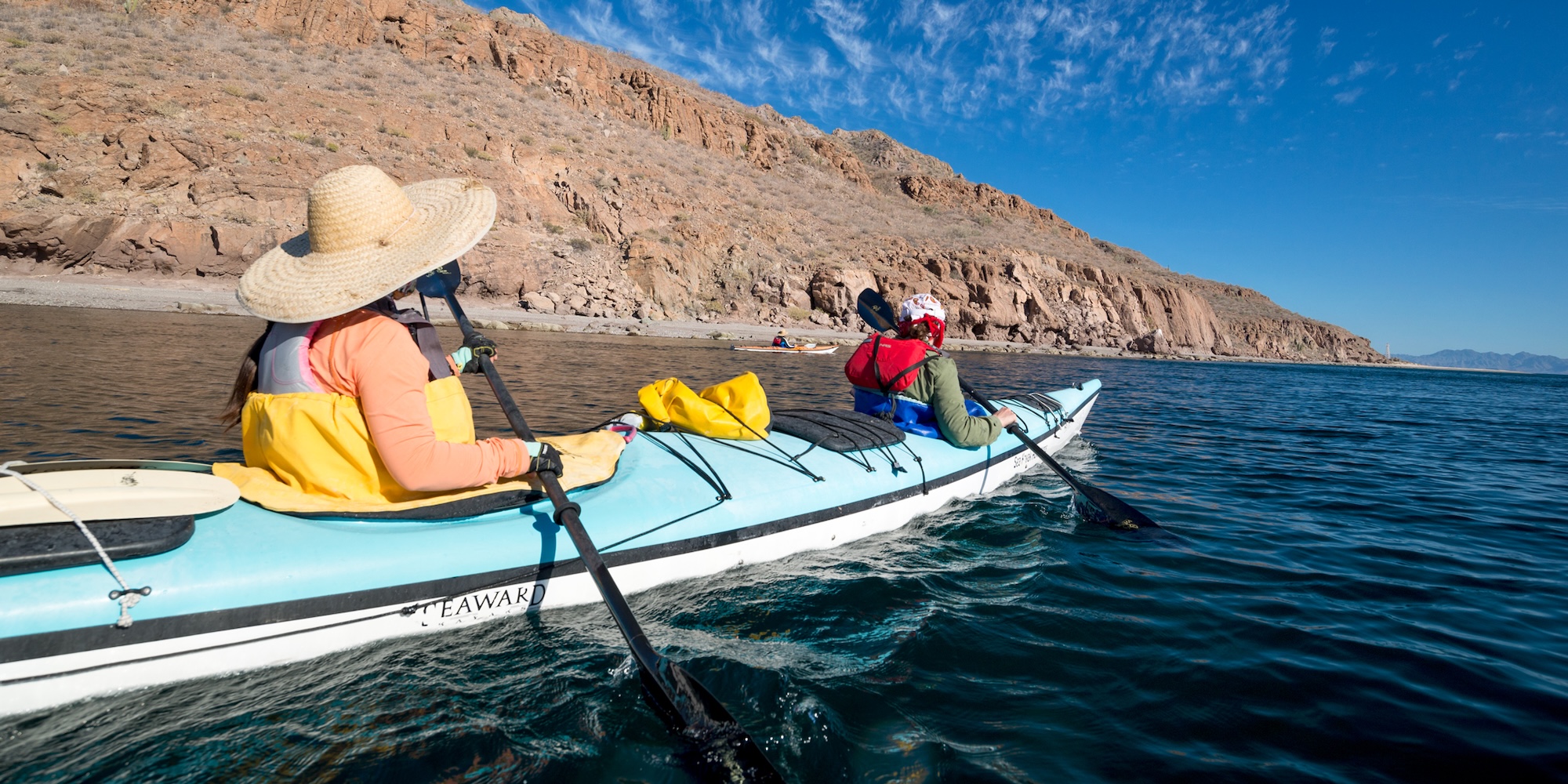 Two sea kayakers paddling towards shore in Baja, California. 
