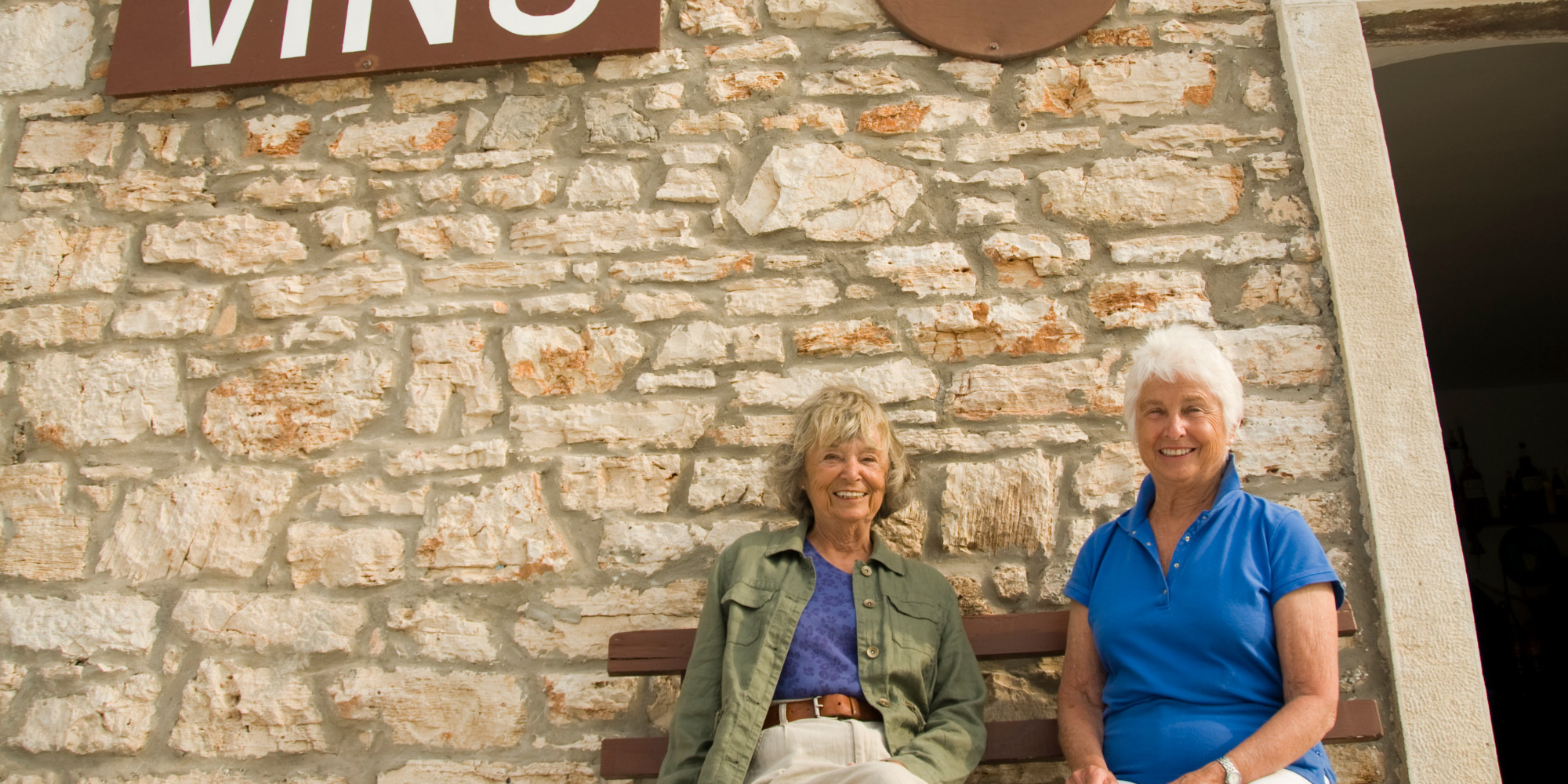 Two travelers sitting on a bench outside of a winery in Croatia. 