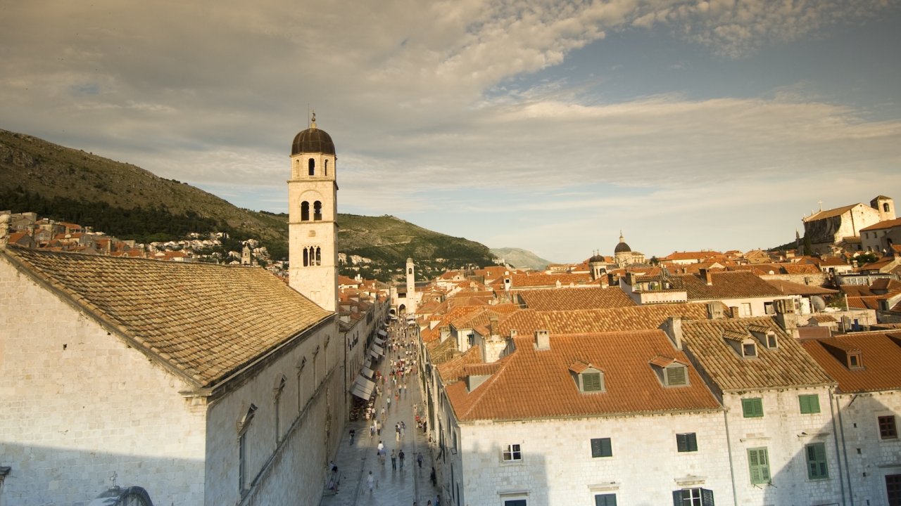 View across Dubrovnik's historic Old Town with its iconic stone buildings, bell towers, and red tile rooftops.