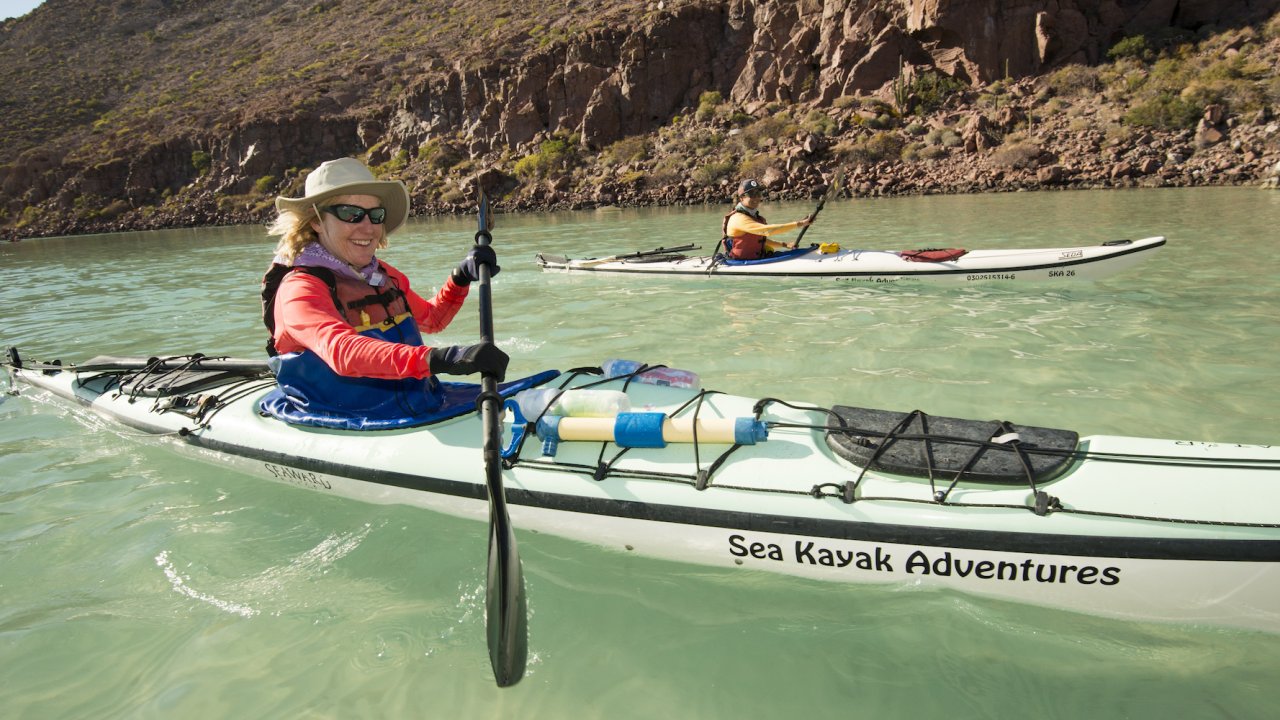 Person paddling a white kayak in the Gulf of California on a sunny day
