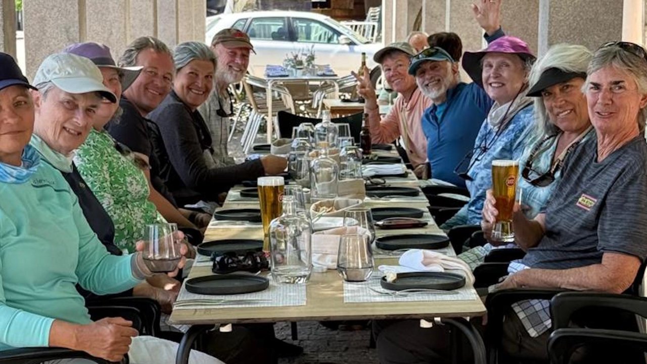A group of kayakers in Portugal gathered around a table for dinner in Porto