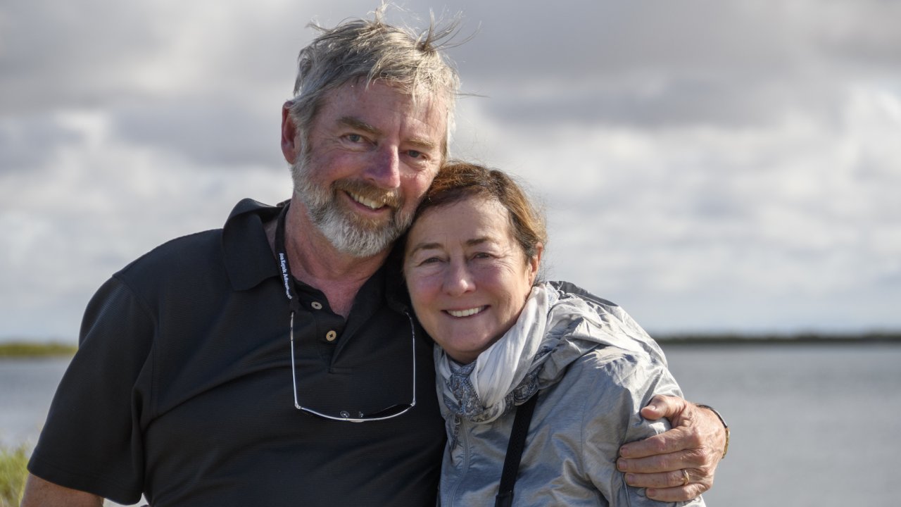 A couple smiling while on a whale watching tour outside of La Paz