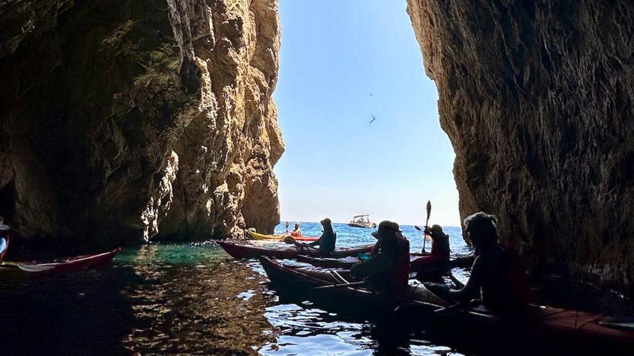 Sea kayakers exploring a cave off of the coast of Albania.