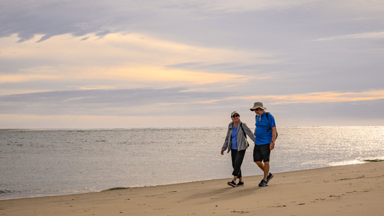 A couple walking along a sandy beach along the Pacific Ocean in Baja California Sur