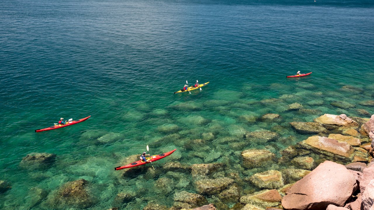 Scenic view of sea kayakers atop crystal clear water in the Sea of Cortez off of Isla Espiritu Santo