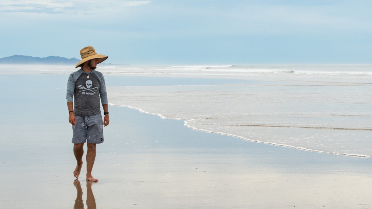 man walking on sandy beach