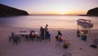 Tables and chairs set up on the beach at sunset on Isla Espiritu Santo