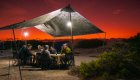 People sitting under a tent at sunset at camp in the Galapagos 