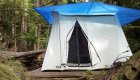 Canvas tent set on a wooden platform beneath trees at a forest camp in British Columbia.