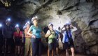 A group of people wearing helmets and headlamps in a cave