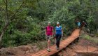 Two women walking over a bridge in the jungle in Cuba