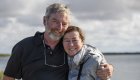 A couple smiling while on a whale watching tour outside of La Paz
