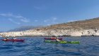 Group of sea kayakers paddling along the European coastline.
