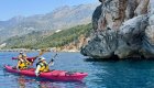 Two people in a tandem sea kayak paddling blue waters in Europe