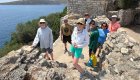 A group of tourists smiling for a photo while hiking through ancient ruins in Montenegro