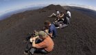 A group of people in the Galapagos Islands sitting on top of volcanic rock
