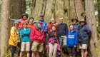 Travelers hiking coastal forest trails as part of a combined hiking and kayaking day tour in Canada.