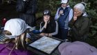 Sea kayaking guests gathered around a map during a guided orca kayaking tour in Johnstone Strait