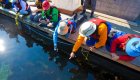 Guests in colorful jackets leaning over a dock to explore marine life at Gods Pocket Resort, combining sea kayak British Columbia tours with a luxury lodge stay in Canada.