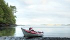 A kayak resting on a quiet beach along the British Columbia coast, a perfect spot for multi-day sea kayaking and whale watching tours in Canada.