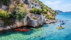 Group of kayakers gliding through crystal-clear water along the Mediterranean coast, showcasing one of the best kayaking destinations in Europe.