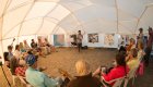 group of travelers listening to whale presentation in dome tent