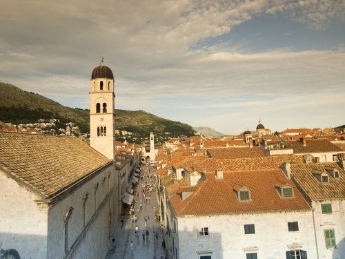 View across Dubrovnik's historic Old Town with its iconic stone buildings, bell towers, and red tile rooftops.