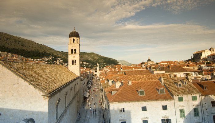 View across Dubrovnik's historic Old Town with its iconic stone buildings, bell towers, and red tile rooftops.